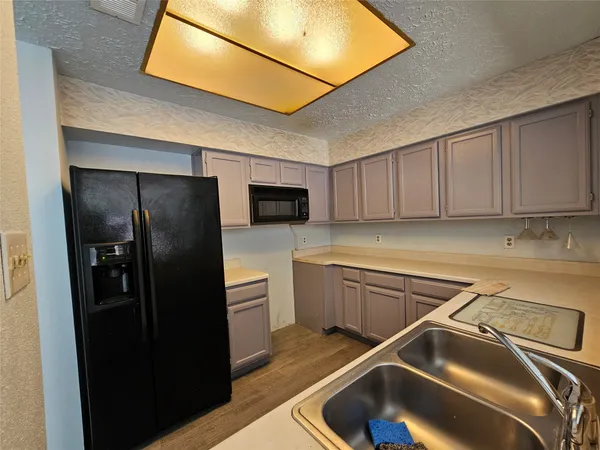 a kitchen with a refrigerator sink and cabinets