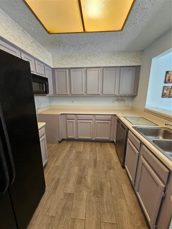 a kitchen with a sink a refrigerator and cabinets