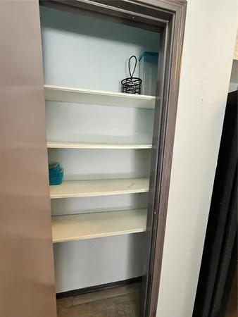 an empty room with wooden floor closet and windows