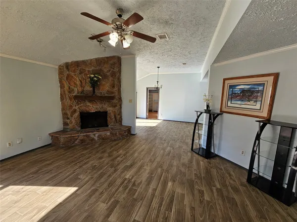 a view of a livingroom with furniture a chandelier fan and wooden floor
