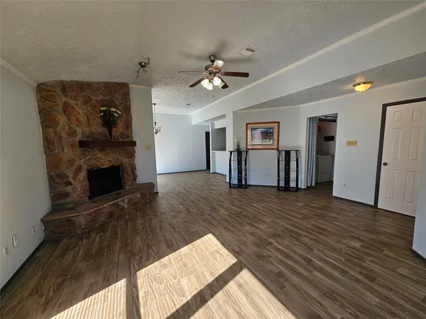 a view of a livingroom with wooden floor and a ceiling fan