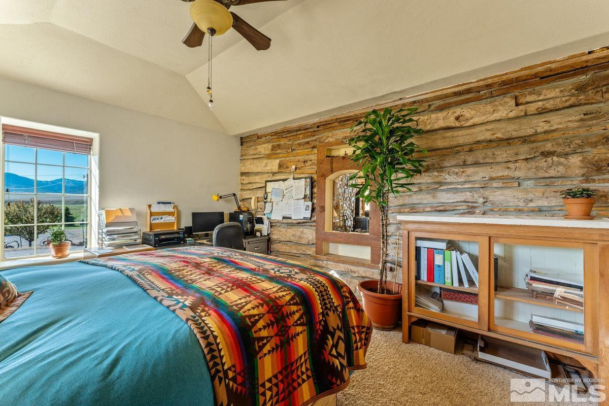 10977 Austin Road Austin, NV 89310 - Photo 12 of 40 a bedroom with a bed a table and a book shelf