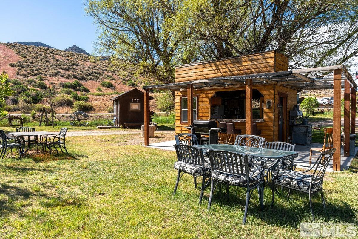 10977 Austin Road Austin, NV 89310 - Photo 29 of 40 a view of a chair and tables in the patio next to a yard