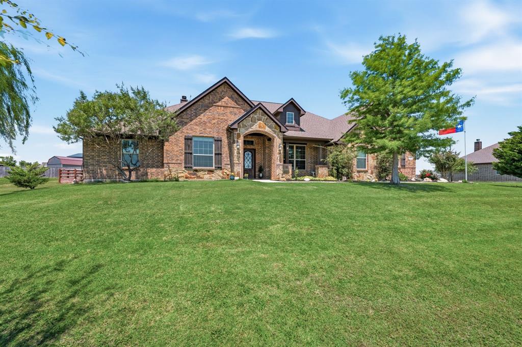 a front view of a house with a yard and trees