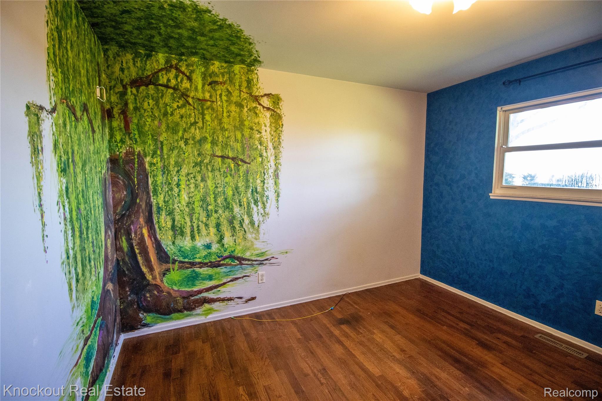 5796 East Burt Road Birch Run, MI 48415 - Photo 17 of 41 Wood-finish flooring with a painted accent wall and an additional textured wall