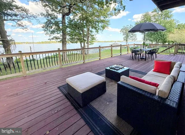 an outdoor sitting area with furniture and wooden floor