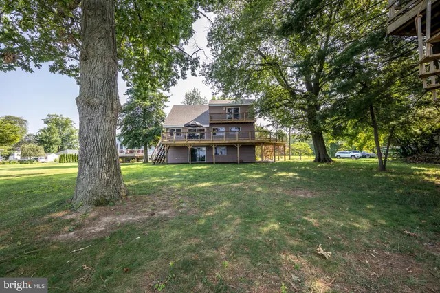 a backyard of a house with wooden floor and outdoor seating