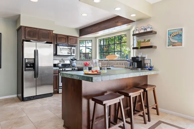 a kitchen with granite countertop a refrigerator and a sink