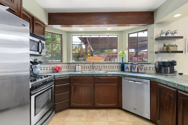 a kitchen with stainless steel appliances granite countertop a sink and a stove