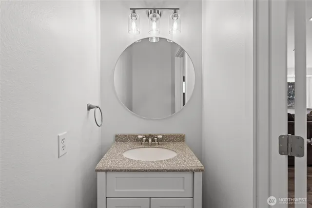 a bathroom with a granite countertop sink and a mirror