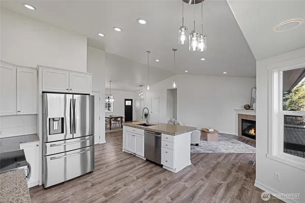 a open kitchen with stainless steel appliances granite countertop a refrigerator and a stove top oven