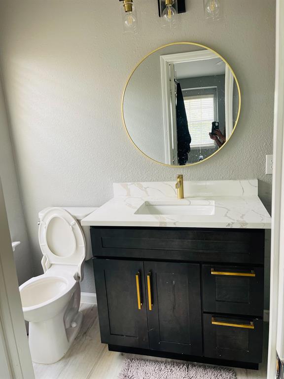 516 Angela Lane Euless, TX 76039 - Photo 24 of 39 Bathroom with a textured wall, vanity, and light wood-style flooring