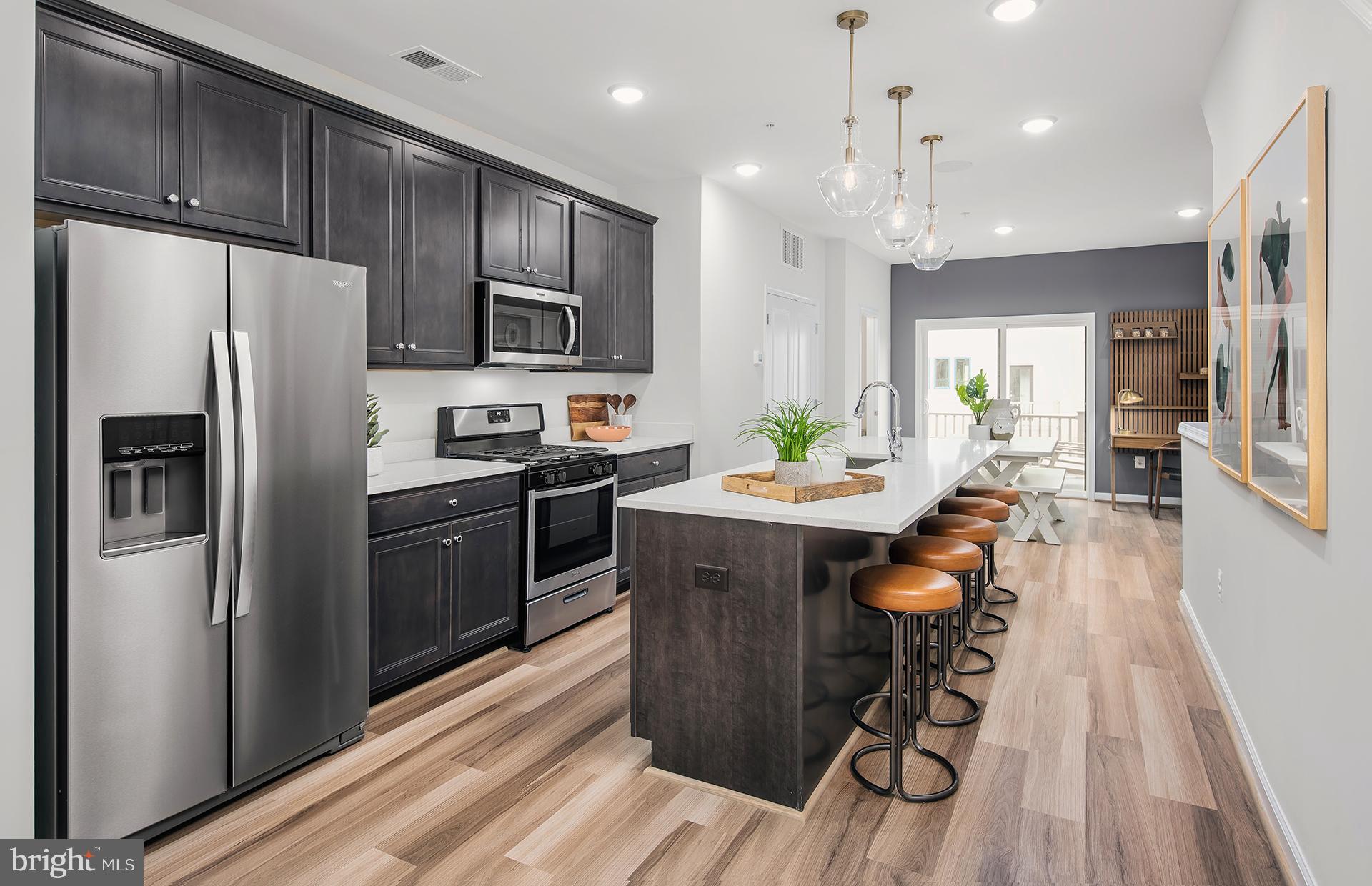 201 Intertidal Lane Laurel, MD 20724 - Photo 2 of 29 a kitchen with stainless steel appliances kitchen island granite countertop a refrigerator a sink dishwasher a stove and a microwave oven with wooden floor