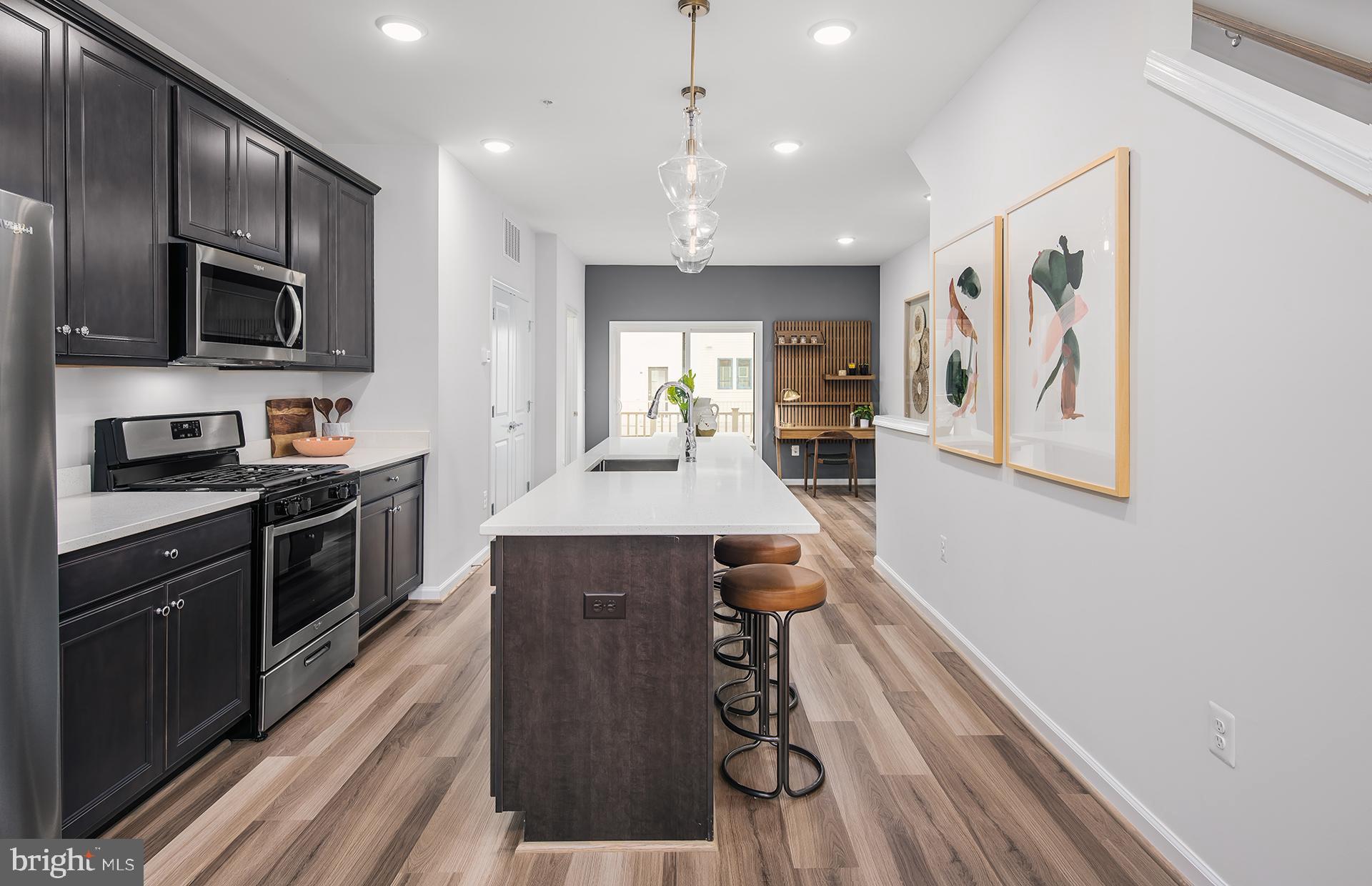 201 Intertidal Lane Laurel, MD 20724 - Photo 4 of 29 a kitchen with stainless steel appliances granite countertop a refrigerator a sink dishwasher a stove and a microwave oven with wooden floor