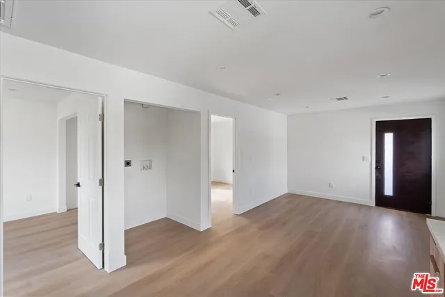 a view of an empty room with wooden floor