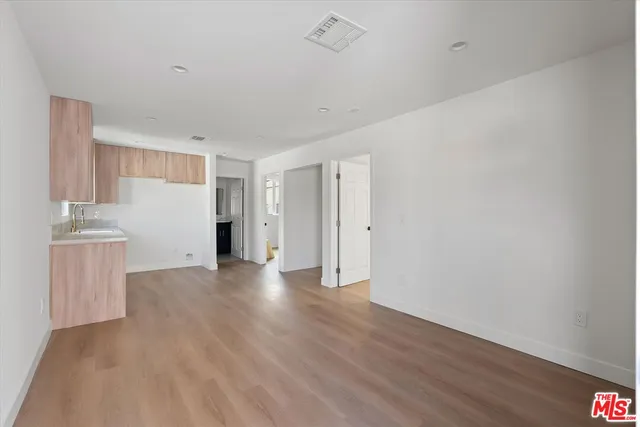 a view of a kitchen with wooden floor and a sink