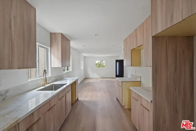 a large kitchen with lot of cabinets and wooden floor