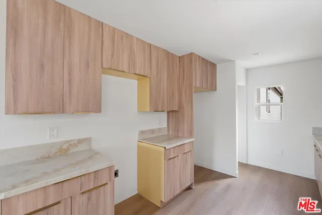 a kitchen with cabinets appliances and a wooden floor