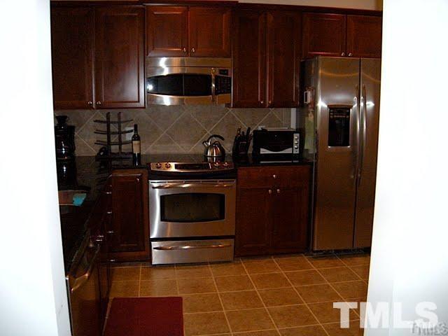 8213 Saltwood Place Raleigh, NC 27617 - Photo 6 of 13 a kitchen with a stove and a refrigerator