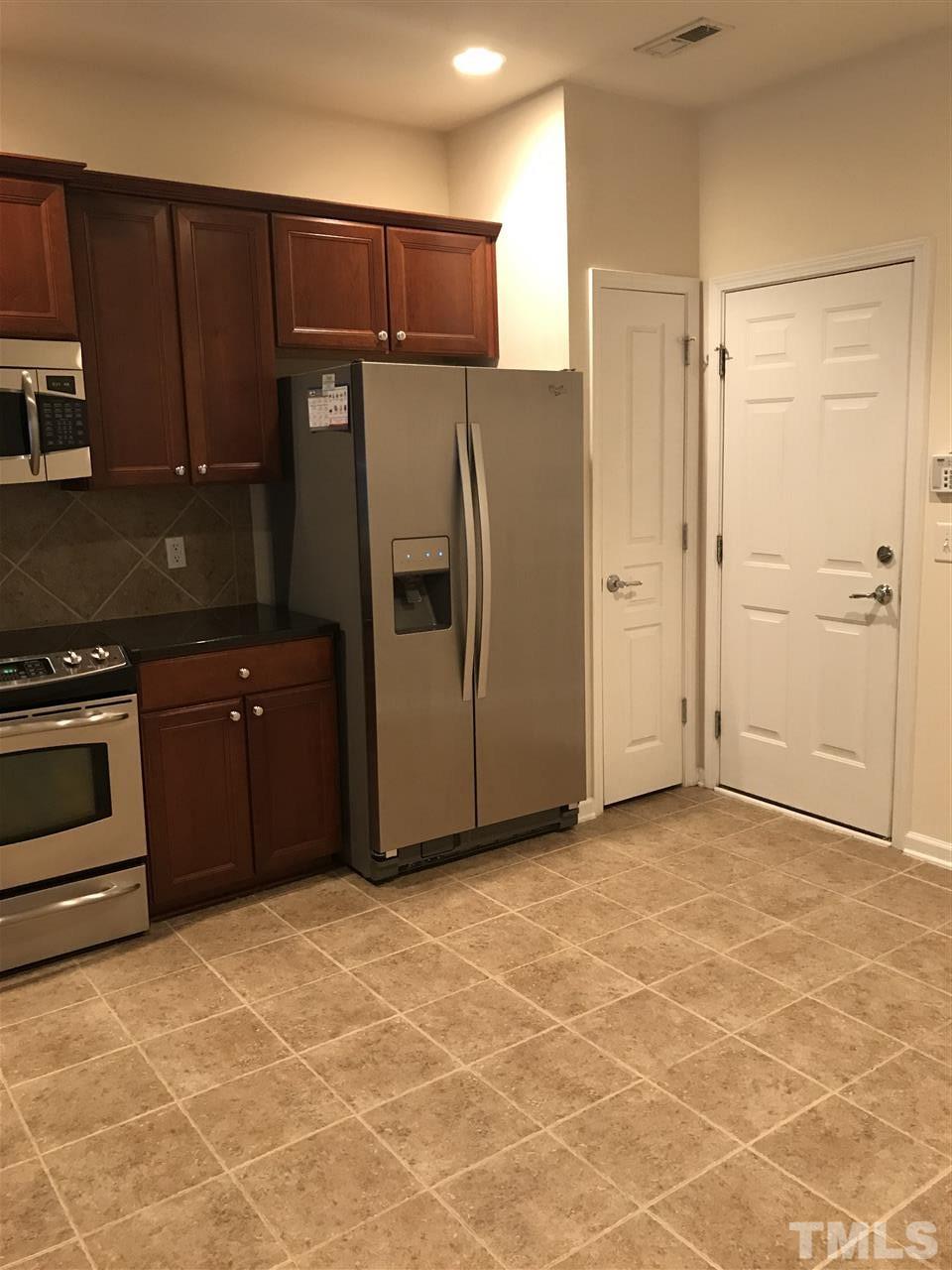 8213 Saltwood Place Raleigh, NC 27617 - Photo 10 of 13 a kitchen with granite countertop a refrigerator and a stove top oven