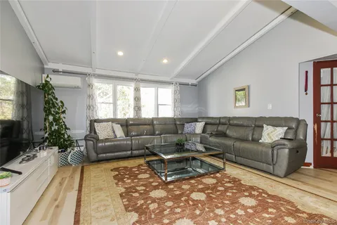 a living room with furniture a rug and a flat screen tv
