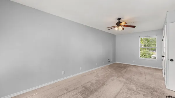 a view of room with a ceiling fan and window