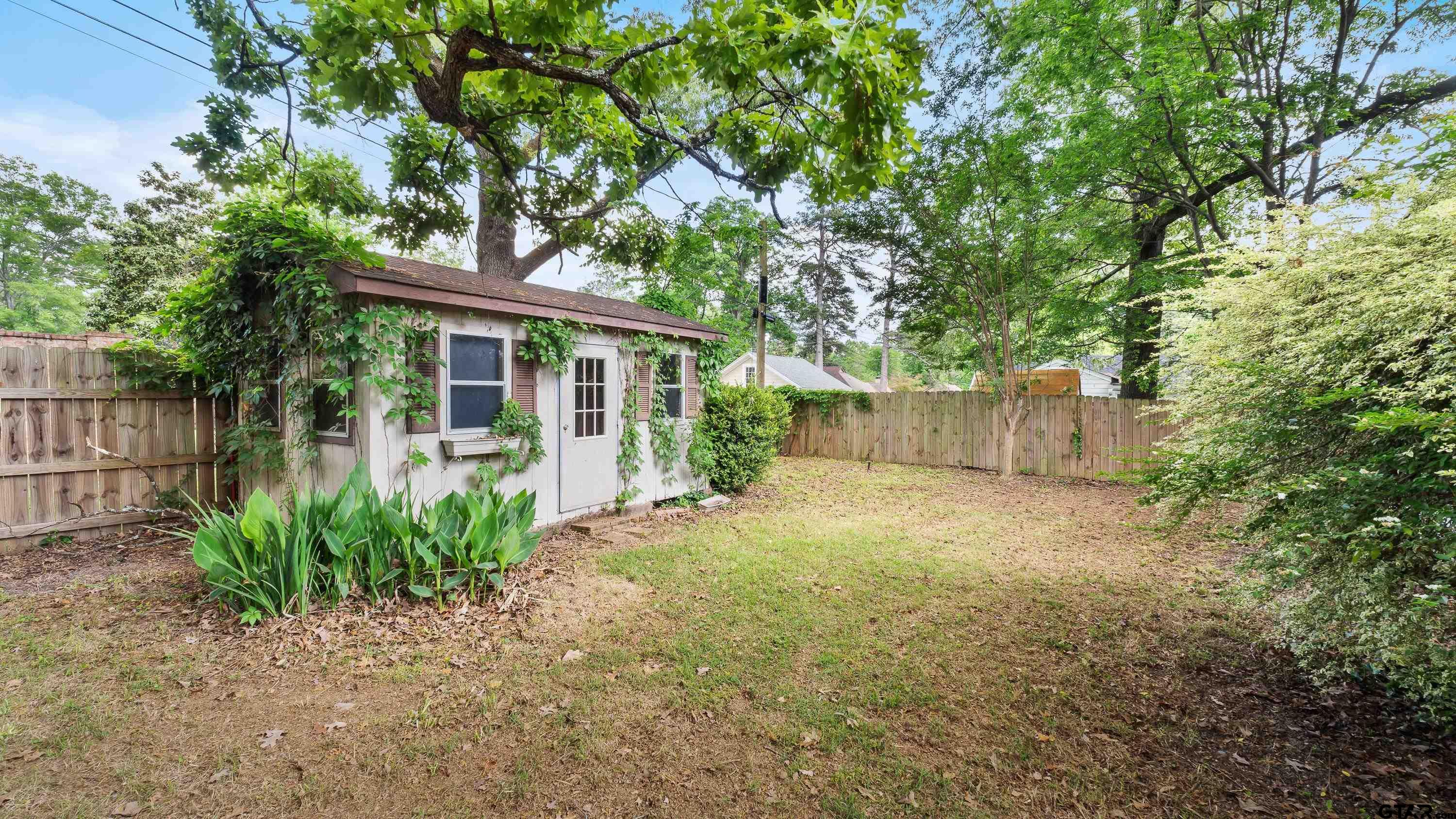 3418 Main Street Texarkana, TX 75503 - Photo 24 of 28 a view of a backyard with plants and large tree