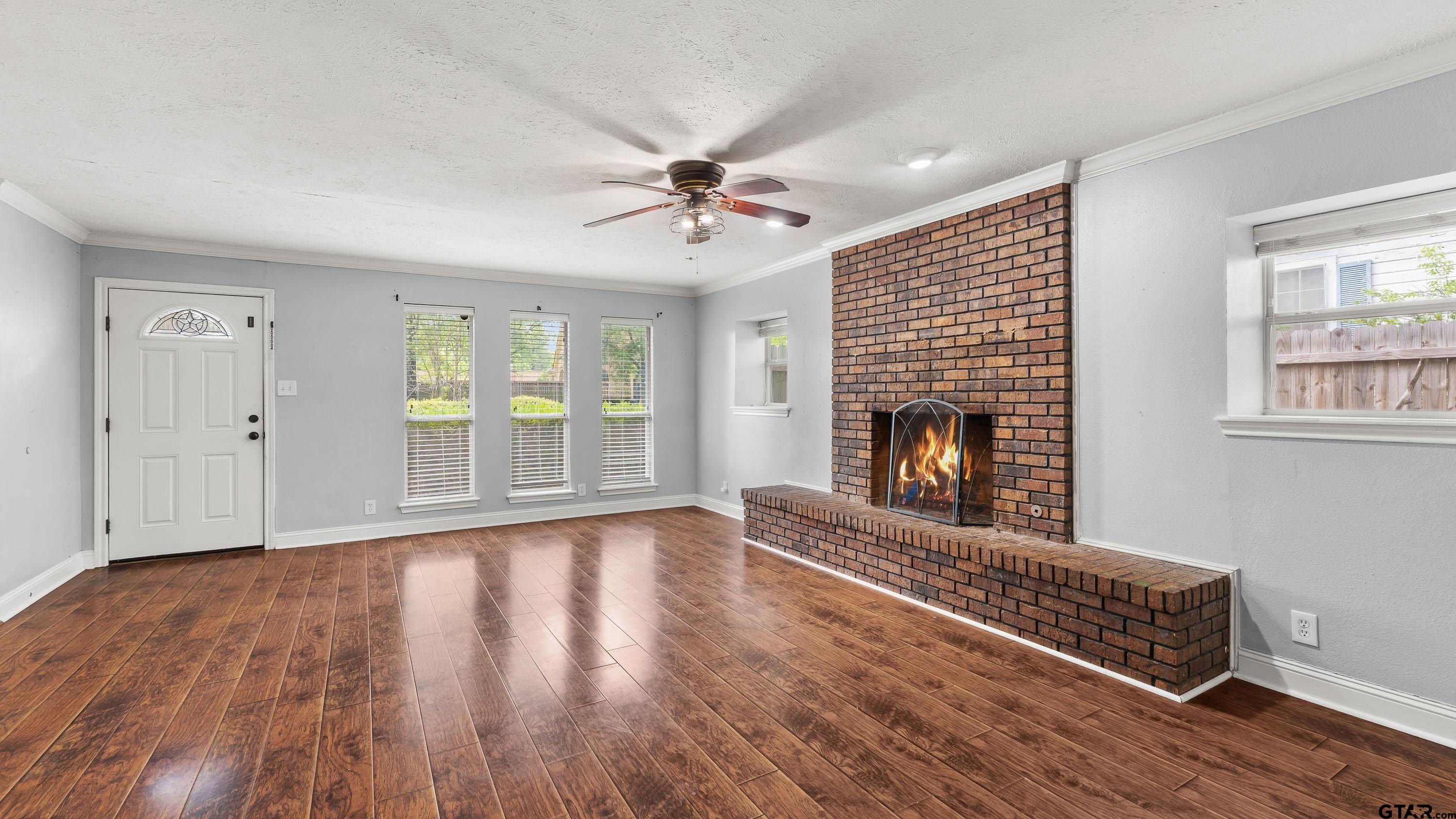 3418 Main Street Texarkana, TX 75503 - Photo 3 of 28 a view of an empty room with wooden floor fireplace and a window