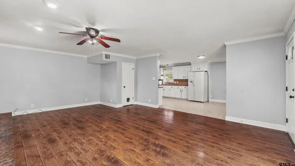 a view of empty room with wooden floor and window