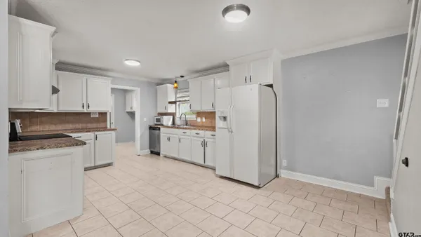 a kitchen with white cabinets and white appliances