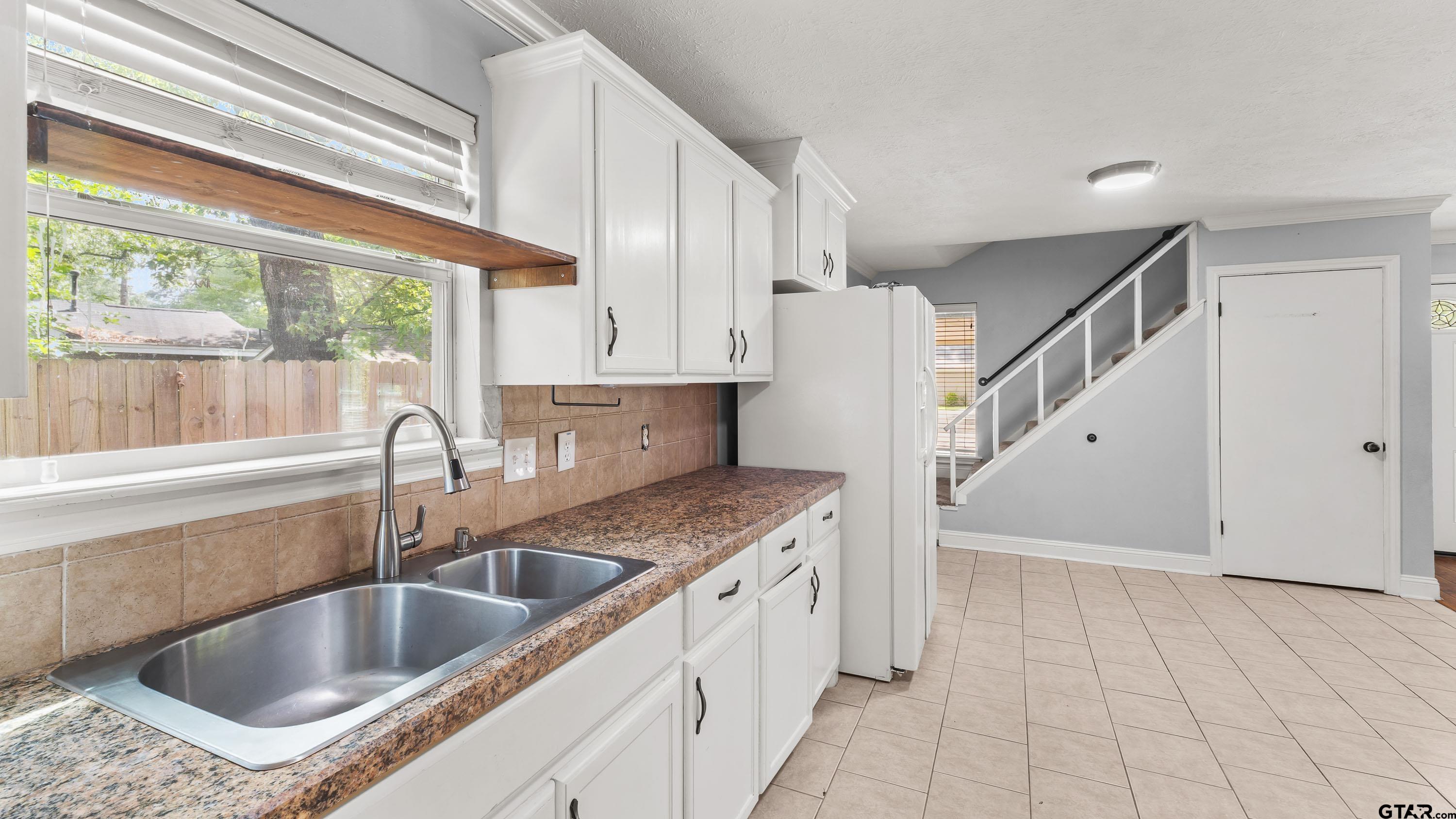 3418 Main Street Texarkana, TX 75503 - Photo 8 of 28 a kitchen with a sink a counter top space cabinets and a window