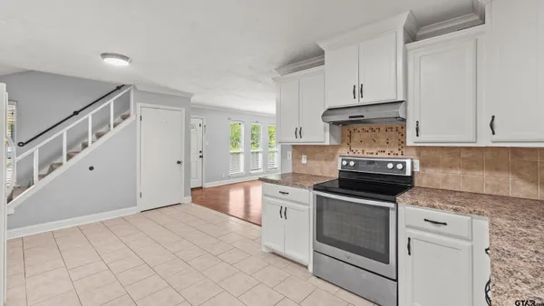 a kitchen with granite countertop white cabinets and white appliances