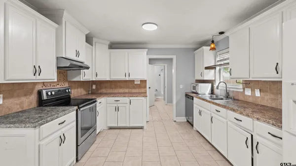 a kitchen with granite countertop white cabinets and white appliances