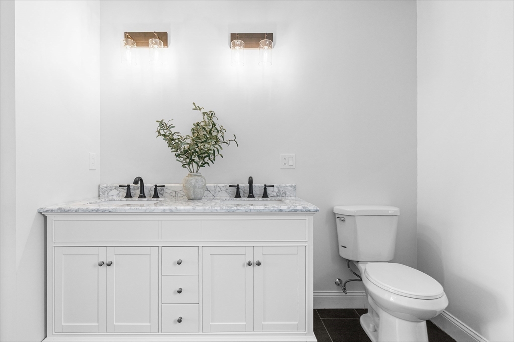15 Jean Street Acushnet, MA 02743 - Photo 18 of 42 a bathroom with a granite countertop toilet sink and mirror