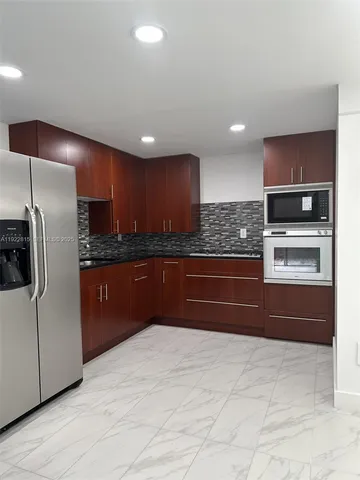 a kitchen with stainless steel appliances granite countertop a refrigerator and a sink