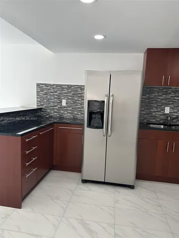 a kitchen with granite countertop a refrigerator and a stove