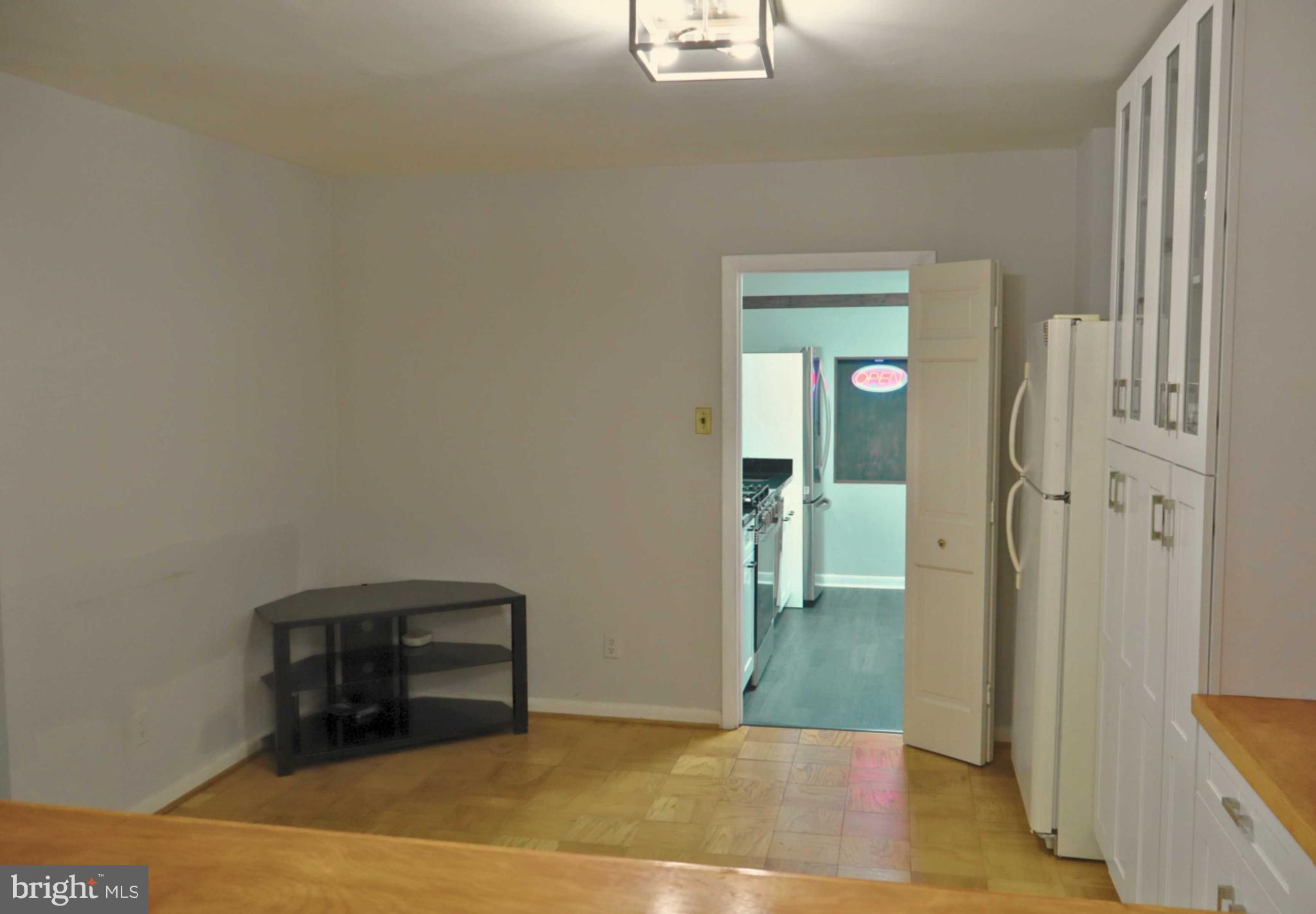 5101 River Road, Unit 405 Bethesda, MD 20816 - Photo 9 of 20 a view of a livingroom with wooden floor and a flat screen tv