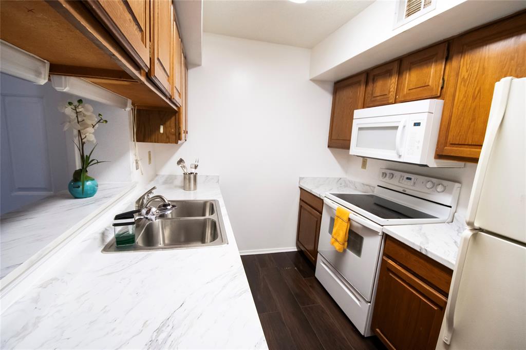 11460 Audelia Road, Unit 272 Dallas, TX 75243 - Photo 5 of 27 a kitchen with stainless steel appliances granite countertop a stove a sink and a microwave