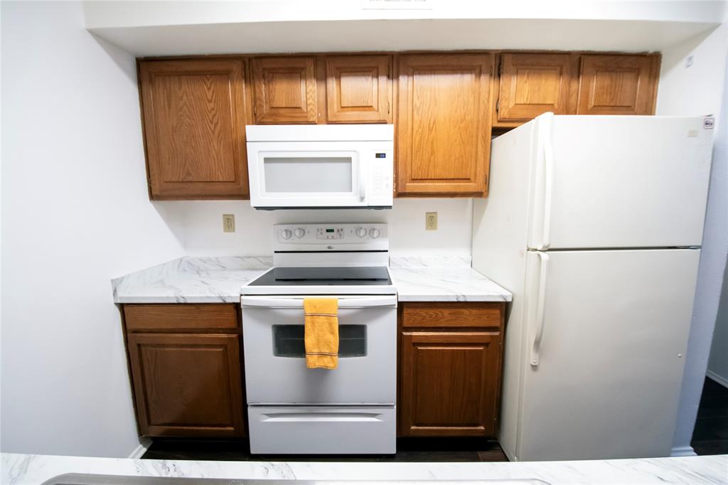11460 Audelia Road, Unit 272 Dallas, TX 75243 - Photo 6 of 27 a kitchen with a refrigerator sink stove and cabinets