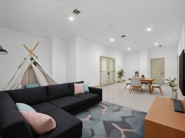 a living room with furniture and a dining table with wooden floor