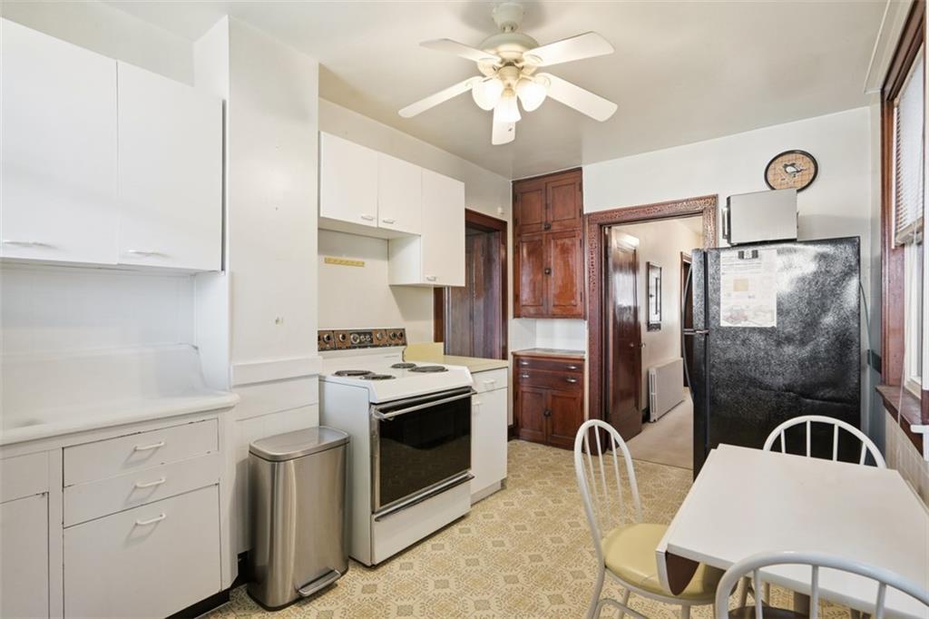 205 Clover Street Pittsburgh, PA 15210 - Photo 18 of 49 a kitchen with stainless steel appliances granite countertop a stove a sink dishwasher a refrigerator with a dining table and chairs