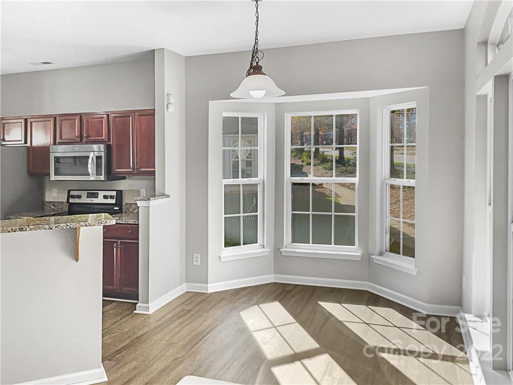 6156 Prosperity Church Road Charlotte, NC 28269 - Photo 18 of 31 a view of an empty room with kitchen and window