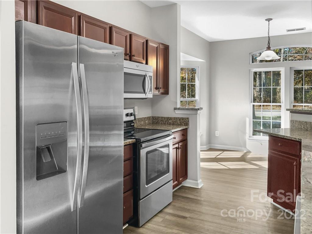6156 Prosperity Church Road Charlotte, NC 28269 - Photo 5 of 31 a kitchen with stainless steel appliances granite countertop a refrigerator a stove and a sink