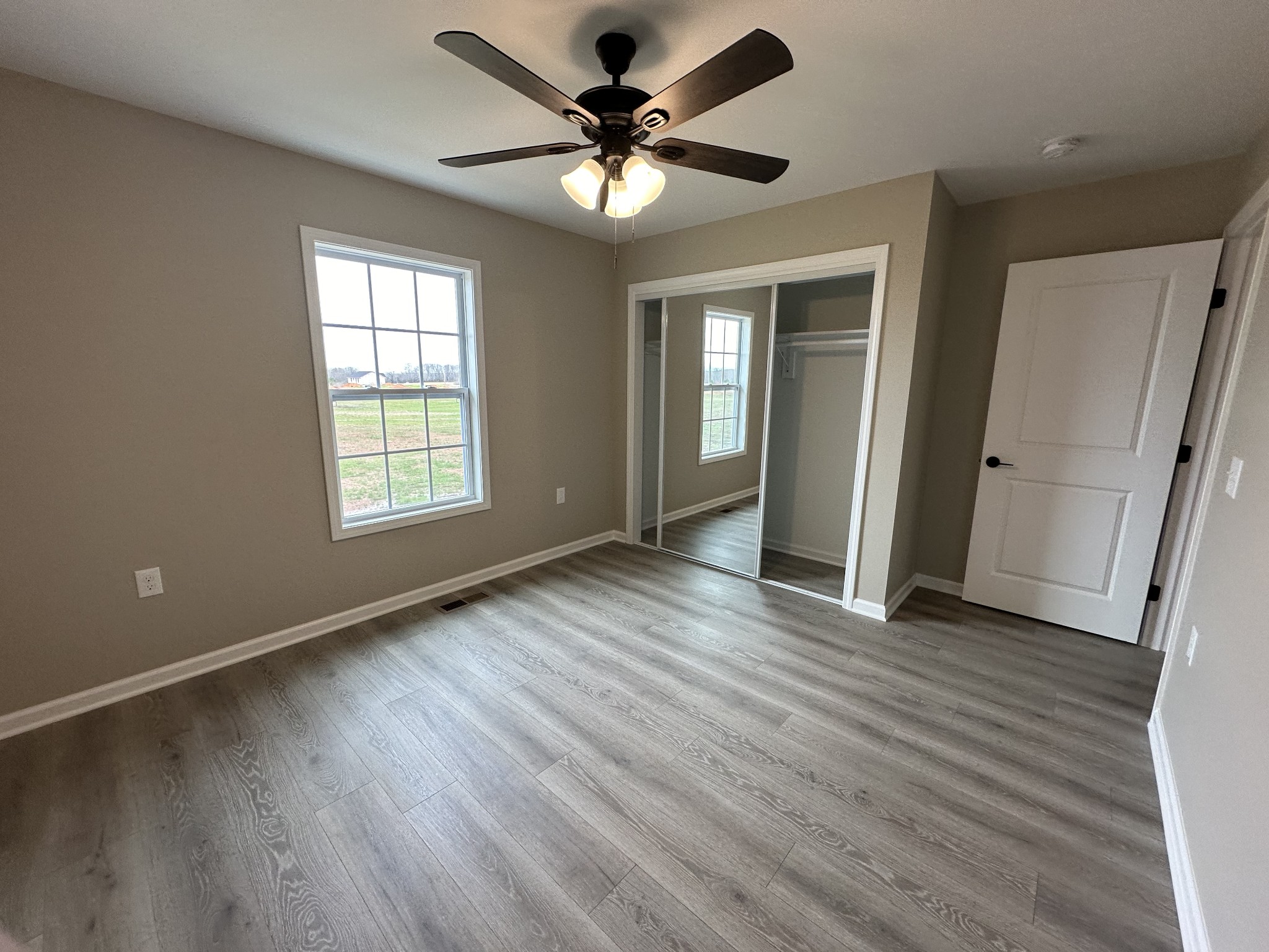 185 Rigling Road Loretto, TN 38469 - Photo 16 of 24 an empty room with wooden floor and windows