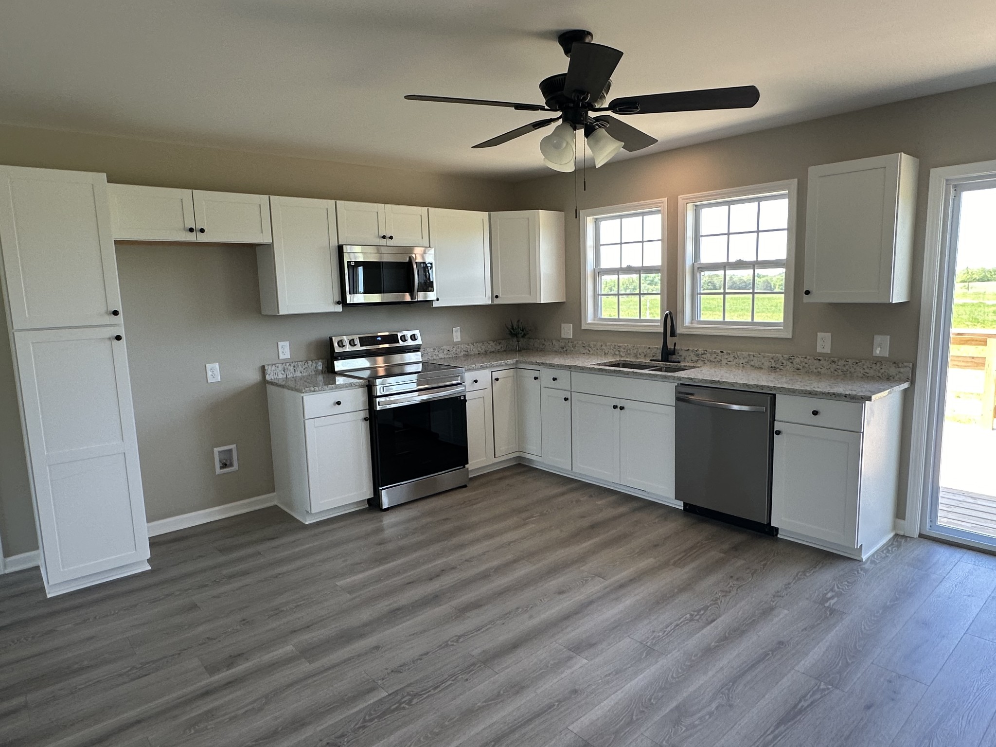 185 Rigling Road Loretto, TN 38469 - Photo 8 of 24 a kitchen with stainless steel appliances granite countertop a sink cabinets and wooden floor