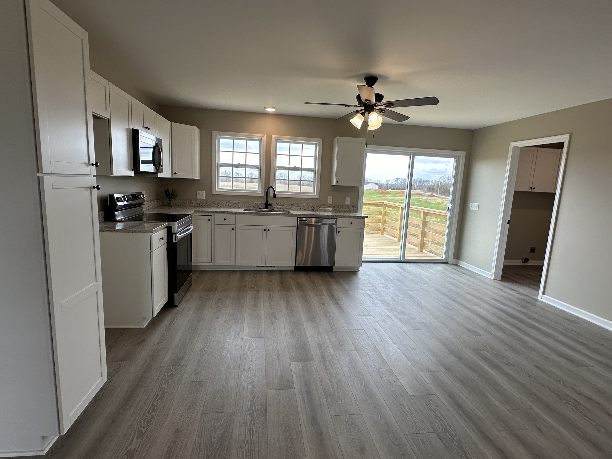 185 Rigling Road Loretto, TN 38469 - Photo 9 of 24 a kitchen with stainless steel appliances granite countertop cabinets wooden floors and a fireplace