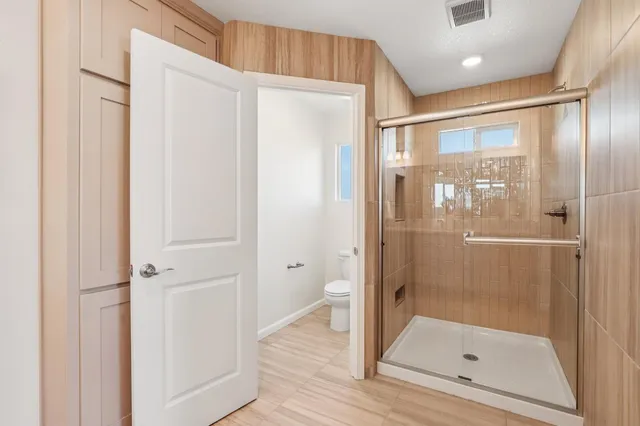 a bathroom with a glass shower door and a glass door shower