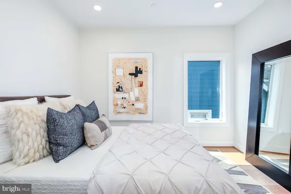 a large bed sitting in a bedroom next to a window and a lamp