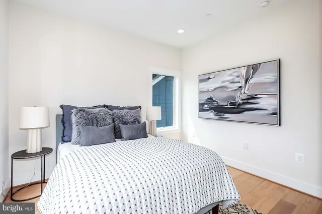 a bedroom with a large bed and a painting on the wall