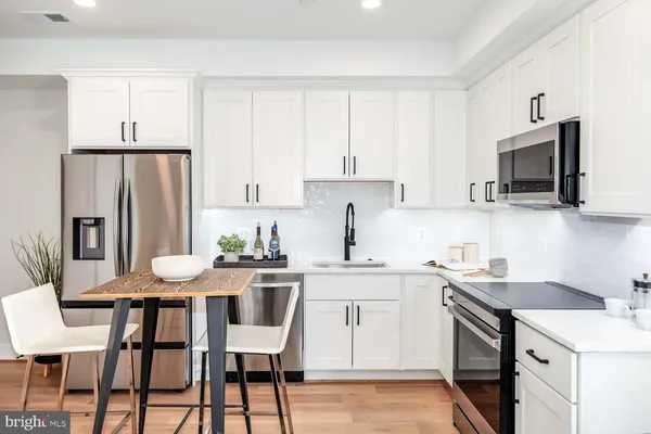 a kitchen with a table chairs refrigerator and microwave